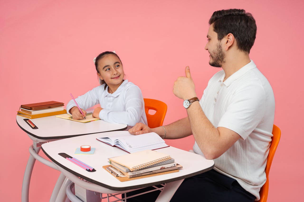 our-story A teacher giving a thumbs-up to a smiling student during a classroom lesson. Education concept.